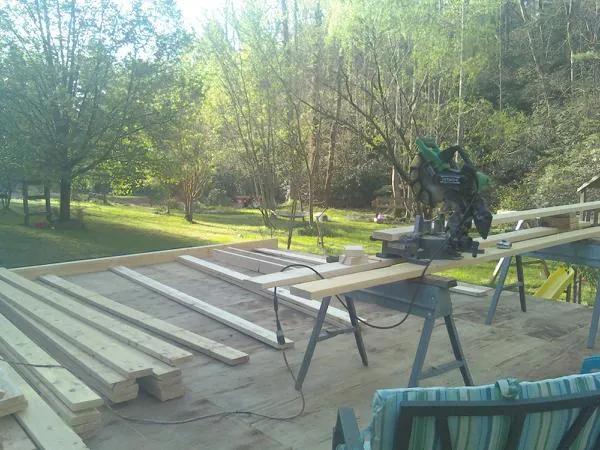 Miter saw and framing lumber on a deck under construction in Norway
